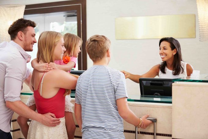 Family Checking In At Hotel Reception